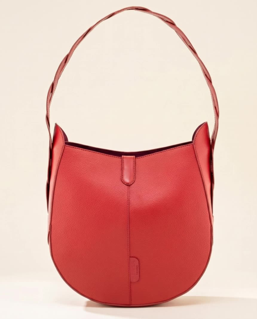 Hand-painted leather shoulder bag turning slowly in warm studio light